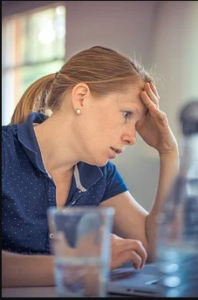 Annoyed Woman sitting with hand on forehead