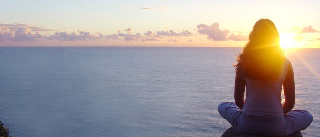 Woman sitting looking at sunset