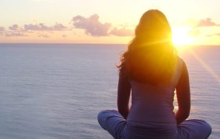 Woman sitting looking at sunset